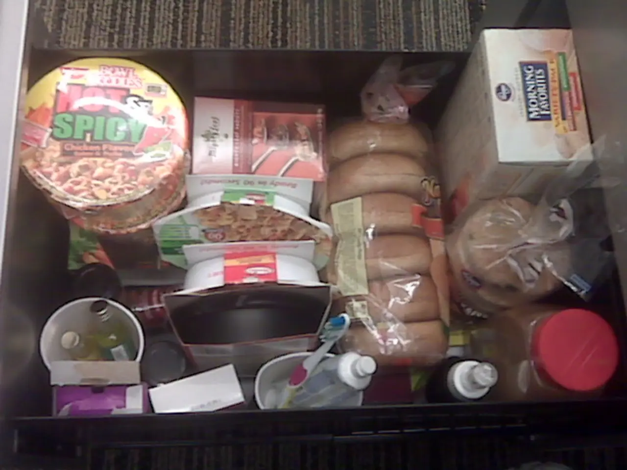 This is a zoomed in picture. In the center there is a box containing bottles, a toothbrush, boxes...