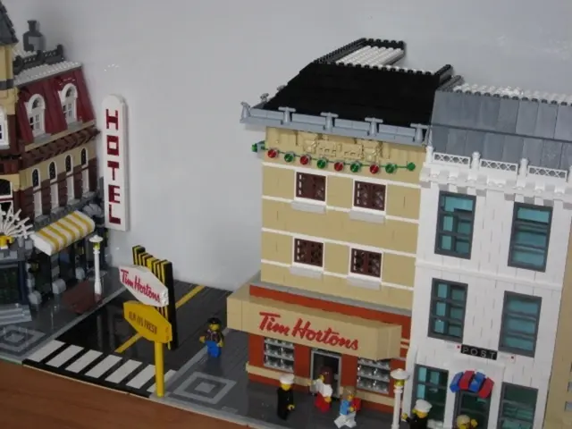 In this picture there are toy buildings on the right and left side of the image, there is a sign...