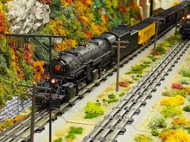 In this picture I can see toys, there are two trains on the tracks, there are poles, plants.