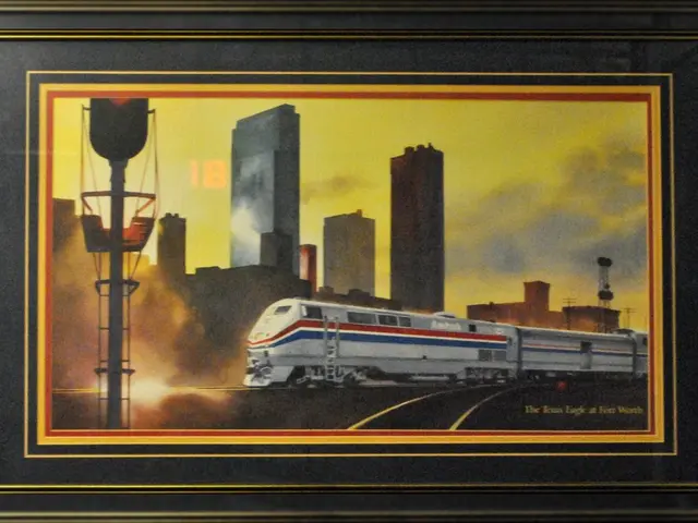 In this image we can see a photo frame, in the photo frame we can see a train, buildings, poles and...